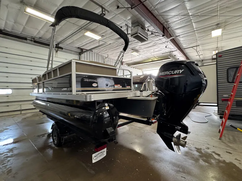 Slide: The Image of 2021 Ranger 200C pontoon boat with Mercury outboard motor in a garage setting. - 4