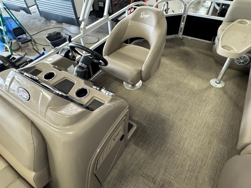 Slide: The Image of Interior of a 2021 Ranger 200C boat with beige seating and steering console. - 9