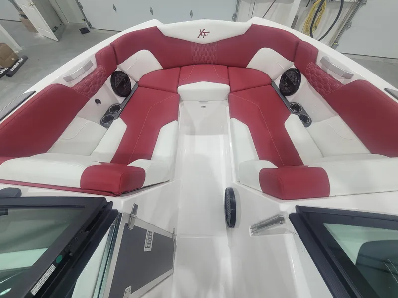 Slide: The Image of 2024 MasterCraft XT24 boat interior with red and white seating. - 12