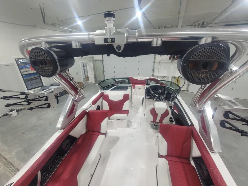 Slide: The Image of 2024 MasterCraft XT24 boat interior with red and white seating, advanced sound system. - 13