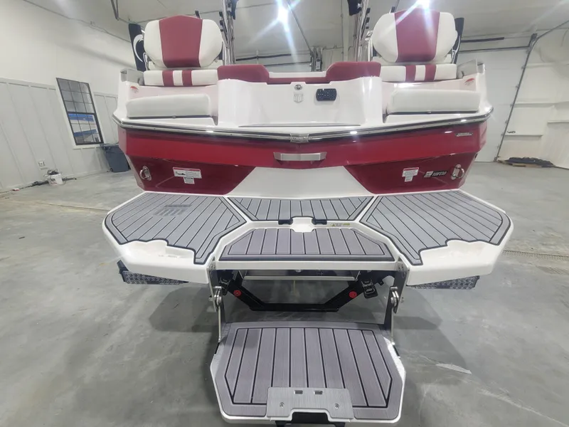 Slide: The Image of 2024 MasterCraft XT24 boat with red and white seating and extended swim platform. - 19
