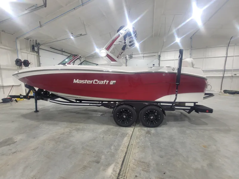 Slide: The Image of 2024 MasterCraft XT24 boat in a showroom, side view. - 22