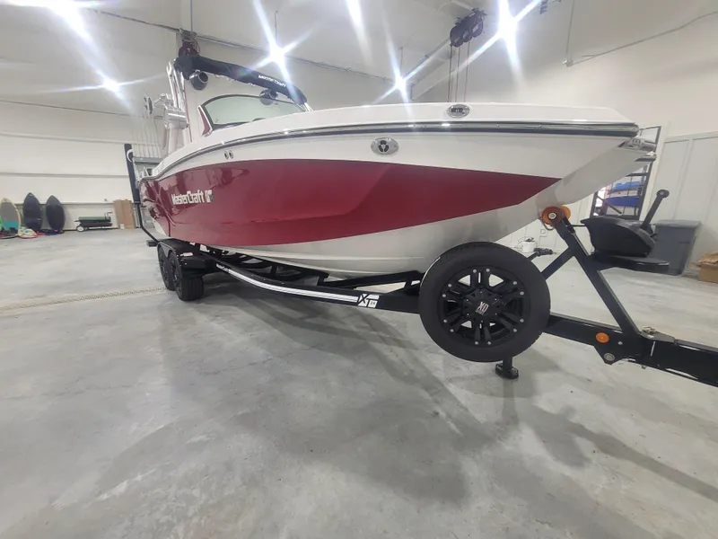 Slide: The Image of 2024 MasterCraft XT24 boat in a showroom, red and white exterior, on a trailer. - 4