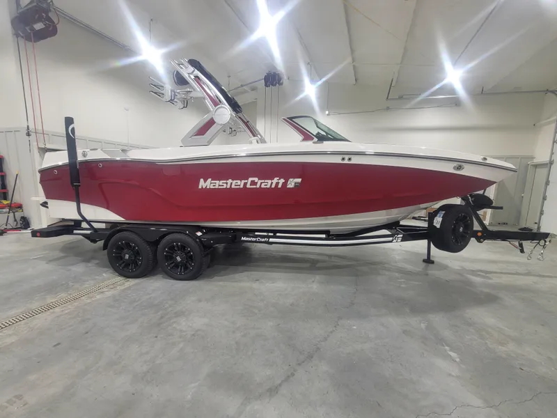 Slide: The Image of 2024 MasterCraft XT24 boat in a showroom, red and white exterior. - 5