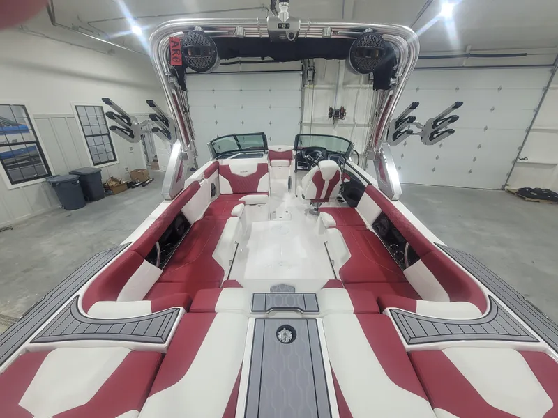 Slide: The Image of 2024 MasterCraft XT24 boat interior with red and white seating in a garage. - 8