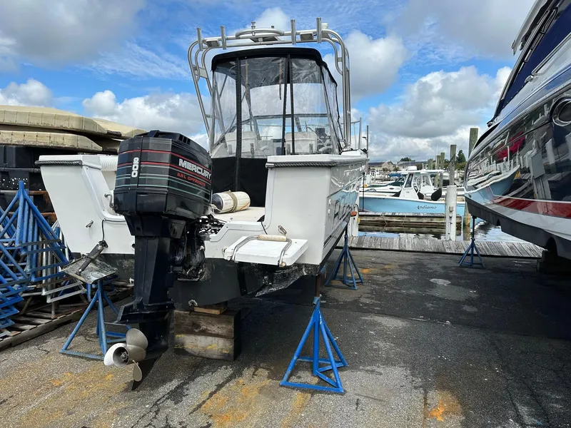Slide: The Image of 1994 Robalo 2160 Cuddy Cabin boat on stands, with outboard motor, docked at marina. - 2