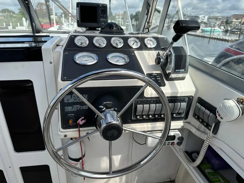 Slide: The Image of 1994 Robalo 2160 Cuddy Cabin helm with steering wheel, gauges, and controls. - 8