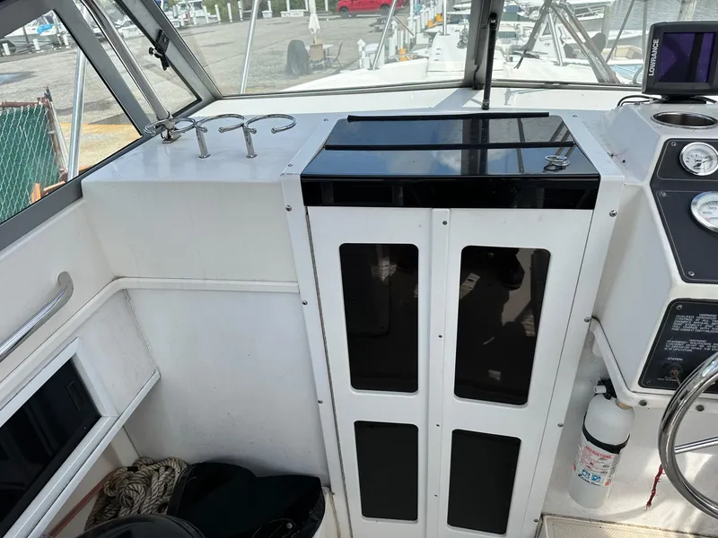 Slide: The Image of 1994 Robalo 2160 Cuddy Cabin boat interior with storage cabinets and control panel. - 9