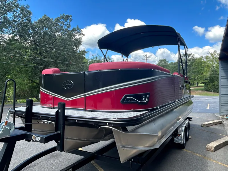 Slide: The Image of 2024 Avalon LSZ 2385 CRB pontoon boat on a trailer, red and black exterior. - 3