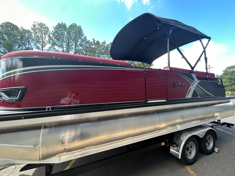Slide: The Image of 2024 Avalon LSZ 2385 CRB pontoon boat with red exterior and black canopy. - 4