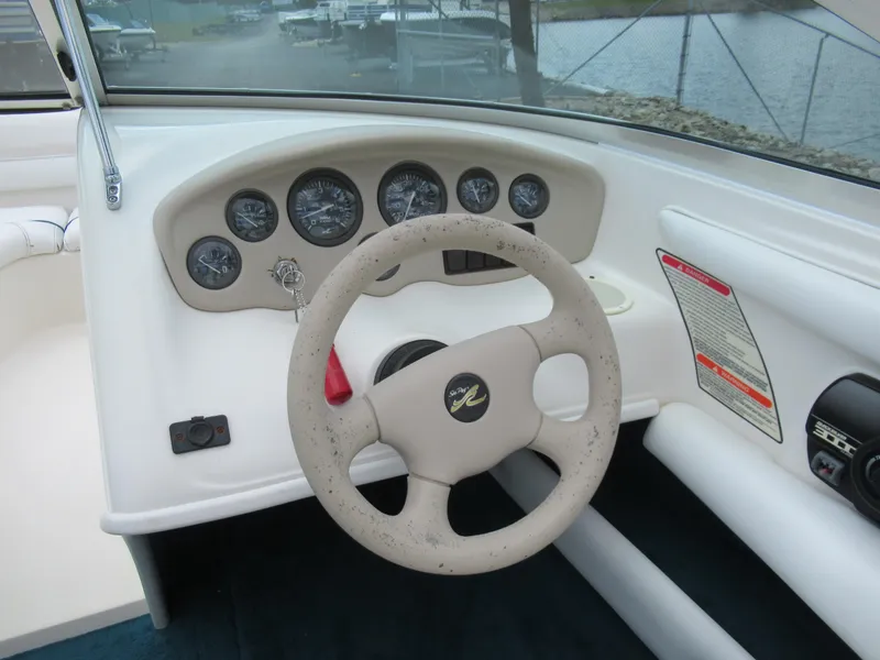 Slide: The Image of 1997 Sea Ray 185 Bow Rider dashboard with steering wheel and gauges. - 12