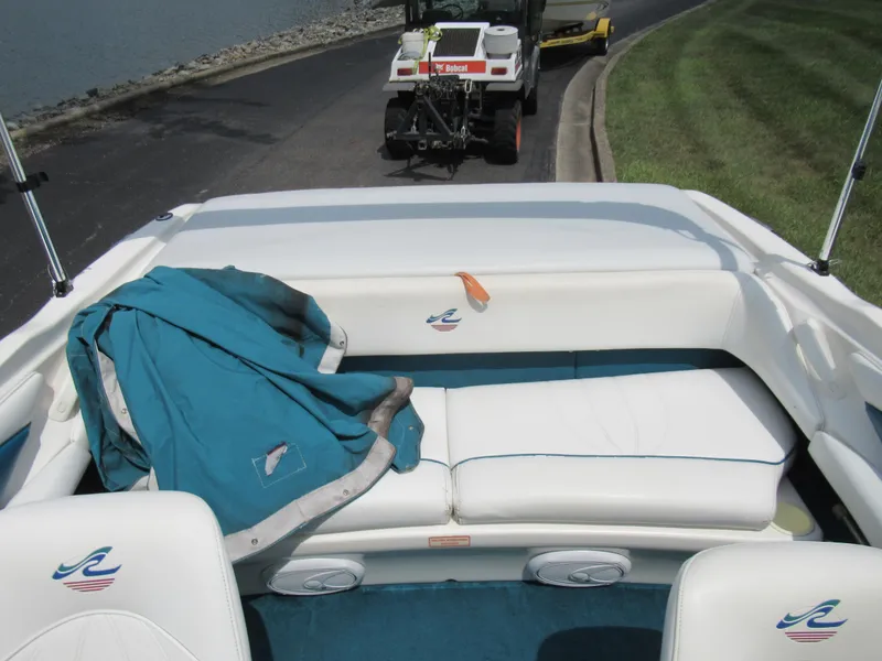 Slide: The Image of 1997 Sea Ray 185 Bow Rider interior with white seating and blue jacket. - 20