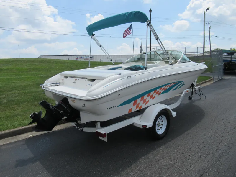 Slide: The Image of 1997 Sea Ray 185 Bow Rider boat with trailer, parked outdoors. - 3