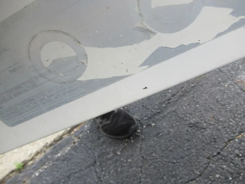 Slide: The Image of Close-up of a 1997 Sea Ray 185 Bow Rider boat hull with peeling decals. - 8