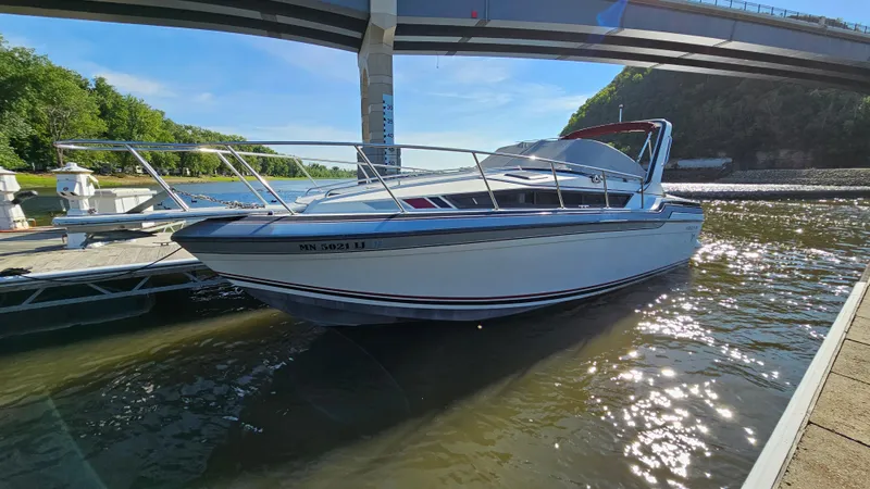 The Image of 1988 Formula 26 PC boat docked under a bridge on a sunny day. - 0