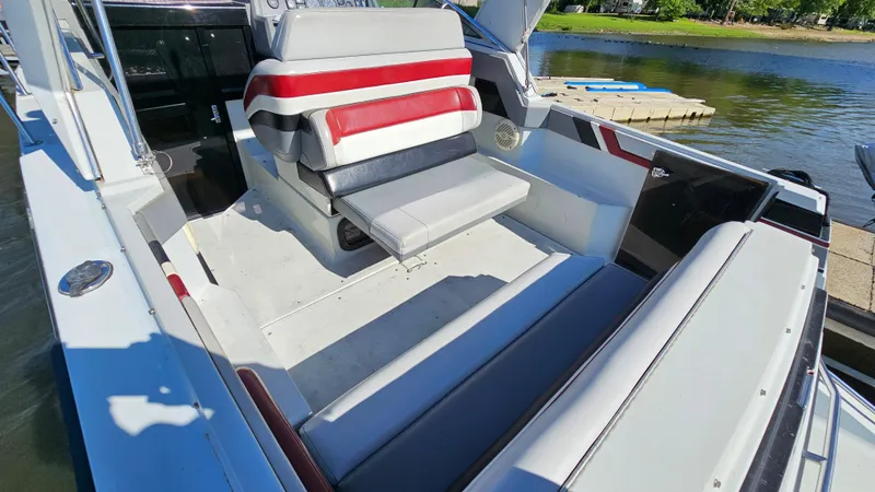 Slide: The Image of 1988 Formula 26 PC boat interior with seating, docked by the water. - 5