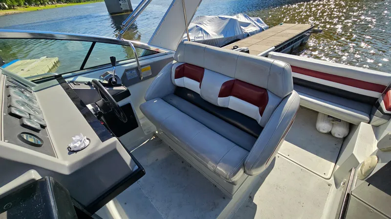 Slide: The Image of 1988 Formula 26 PC boat interior with helm and seating, docked by a lake. - 7