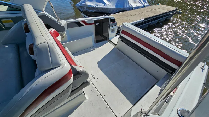 Slide: The Image of 1988 Formula 26 PC boat interior with seating and dock in the background. - 9