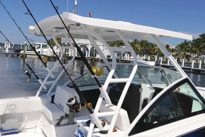 Slide: The Image of 2024 Blackfin 252DC boat with fishing rods docked at a marina. - 10