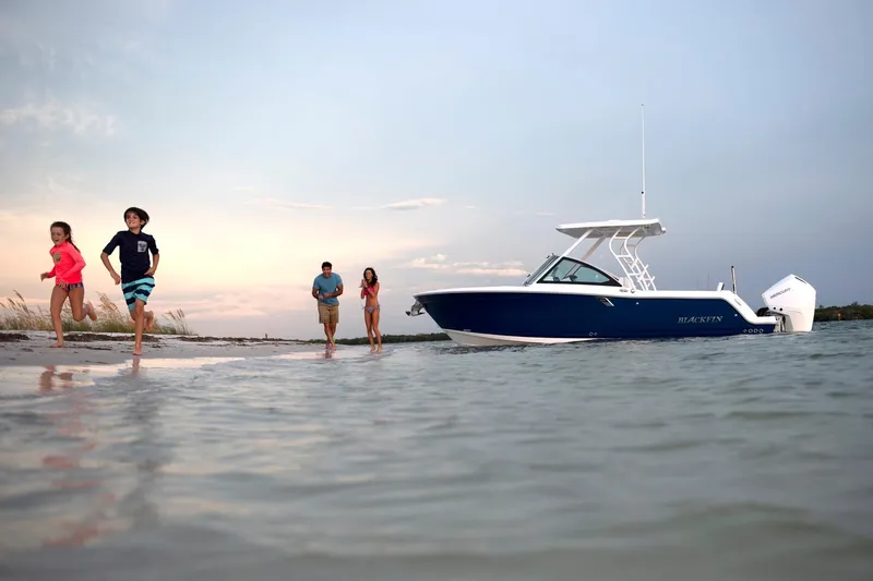 Slide: The Image of Family enjoying beach near 2024 Blackfin 252DC boat at sunset. - 14