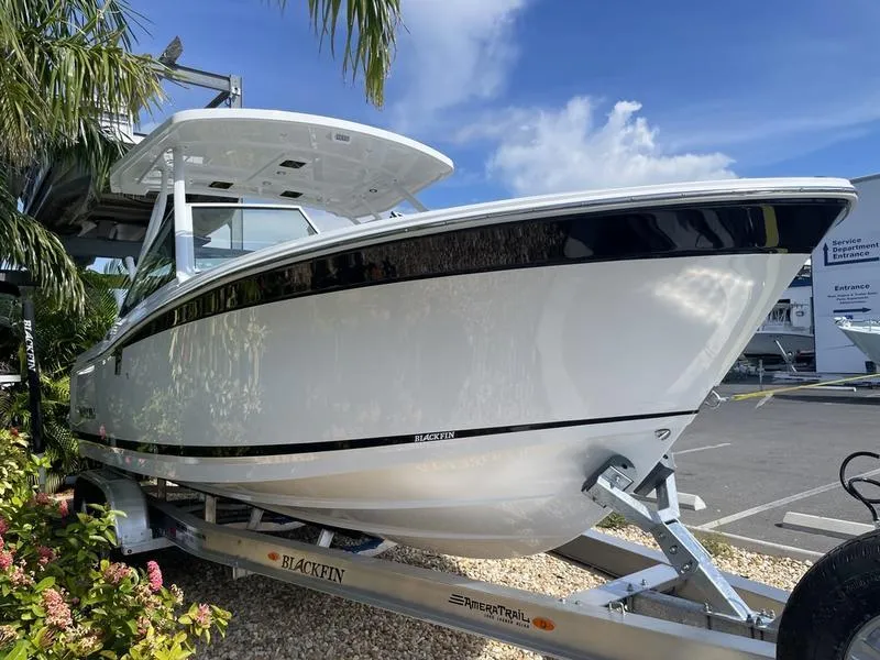 Slide: The Image of 2024 Blackfin 252DC boat on a trailer, parked outdoors. - 2