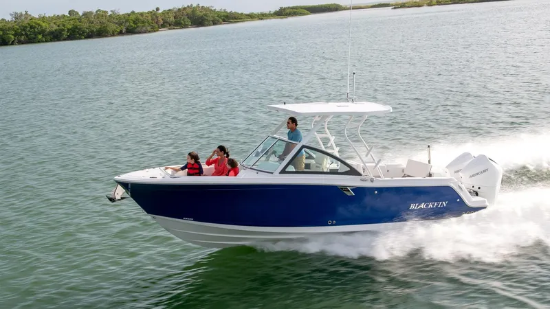 Slide: The Image of 2024 Blackfin 252DC boat cruising on a calm lake with passengers onboard. - 21