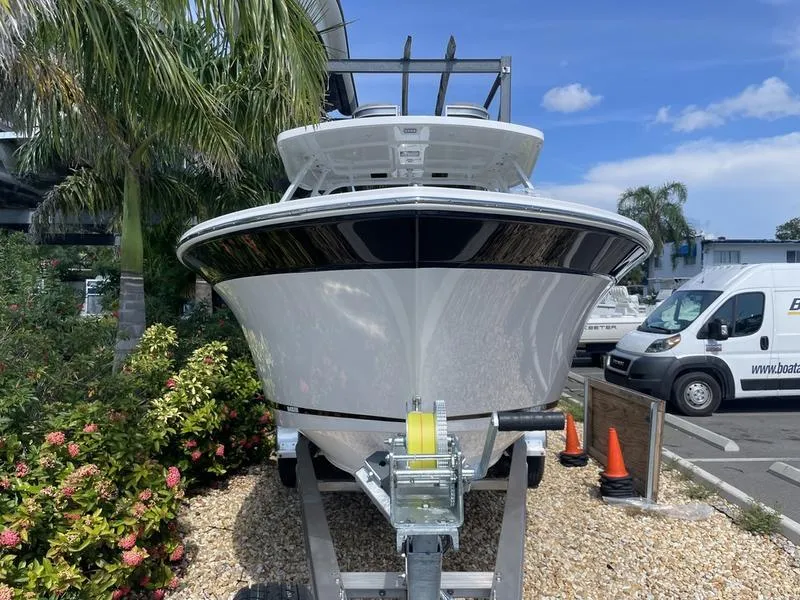 Slide: The Image of 2024 Blackfin 252DC boat on trailer, front view, with palm trees and blue sky. - 3