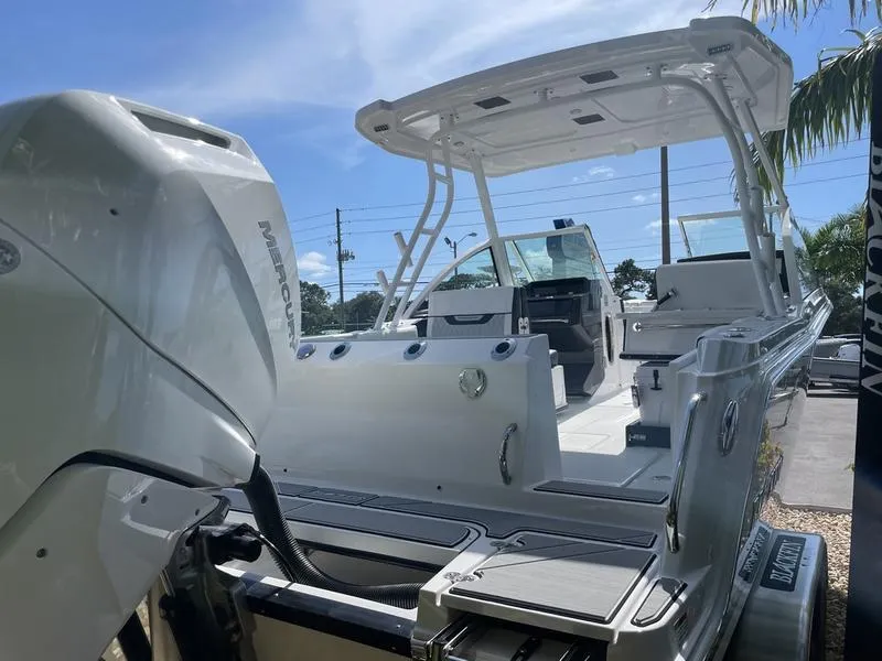 Slide: The Image of 2024 Blackfin 252DC boat with powerful outboard motor, sleek design, and spacious deck. - 5