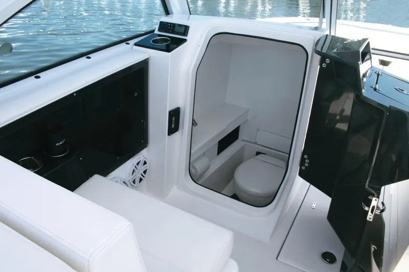 Slide: The Image of 2024 Blackfin 252DC boat interior with compact marine toilet and seating area. - 8