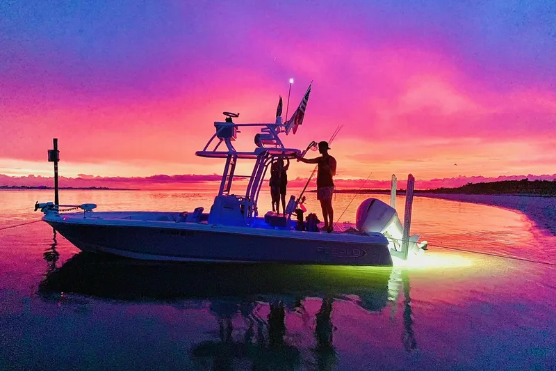 Slide: The Image of 2021 Robalo 246 Cayman SD boat at sunset with vibrant sky. - 0