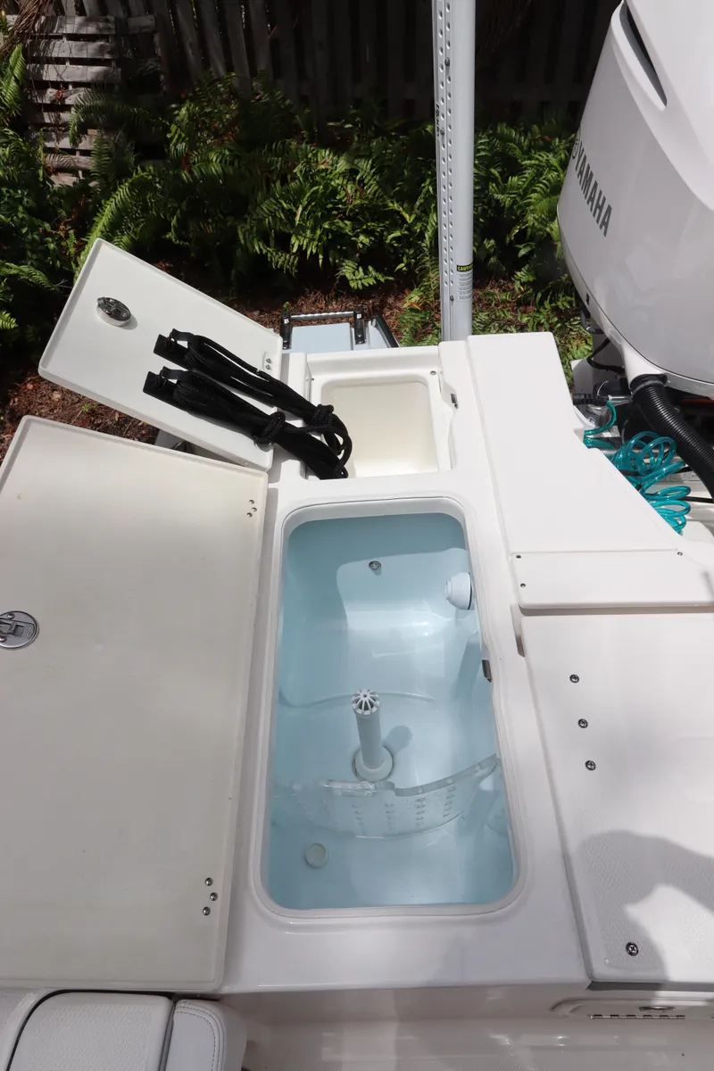 Slide: The Image of 2021 Robalo 246 Cayman SD boat with open storage compartments and Yamaha outboard motor. - 17