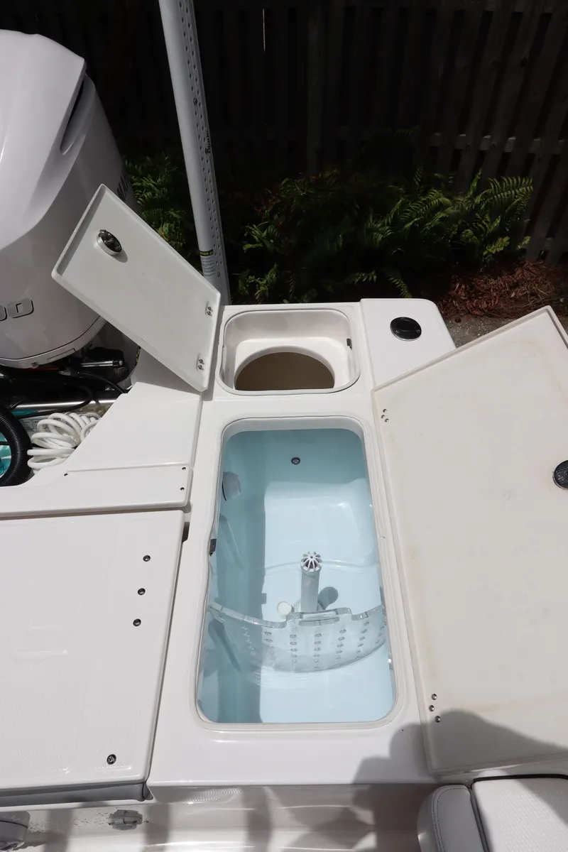 Slide: The Image of 2021 Robalo 246 Cayman SD boat with open storage compartments. - 18