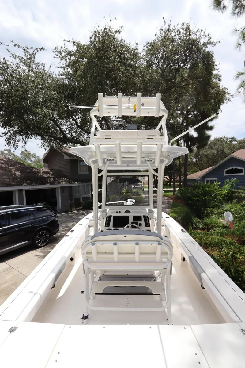 Slide: The Image of 2021 Robalo 246 Cayman SD boat with dual seating and T-top in a residential driveway. - 19