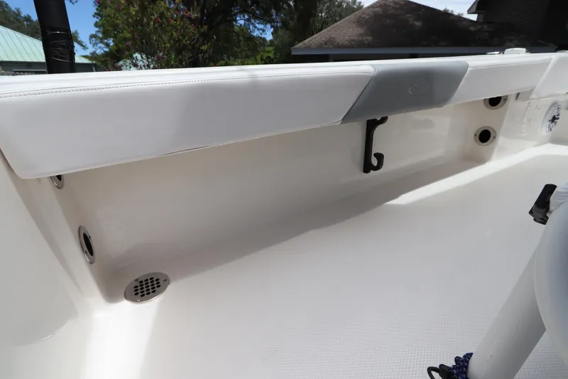 Slide: The Image of 2021 Robalo 246 Cayman SD boat interior detail with white cushioned seating and storage compartments. - 20