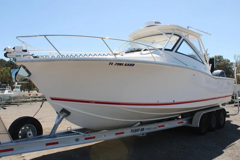 The Image of 2021 Albemarle 30 Express boat on trailer, white hull with red stripe, parked outdoors. - 0