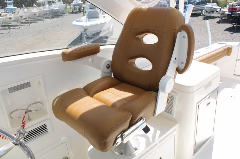 Slide: The Image of Captain's chair on 2021 Albemarle 30 Express boat, featuring tan leather upholstery. - 23