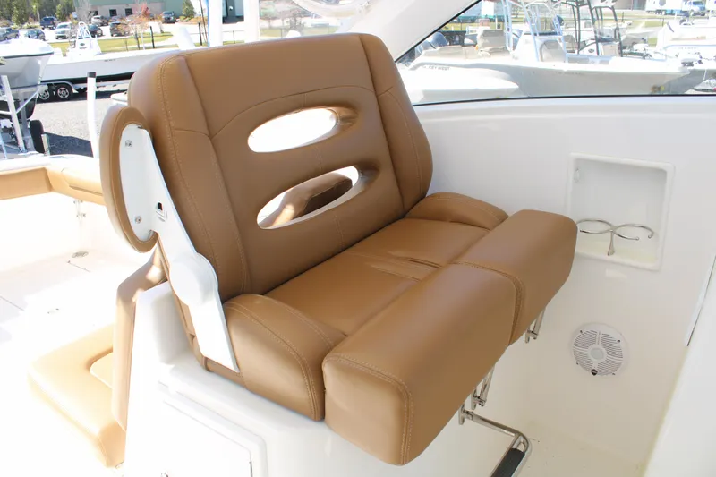 Slide: The Image of Brown leather seat on 2021 Albemarle 30 Express boat, featuring cup holders and speaker. - 24