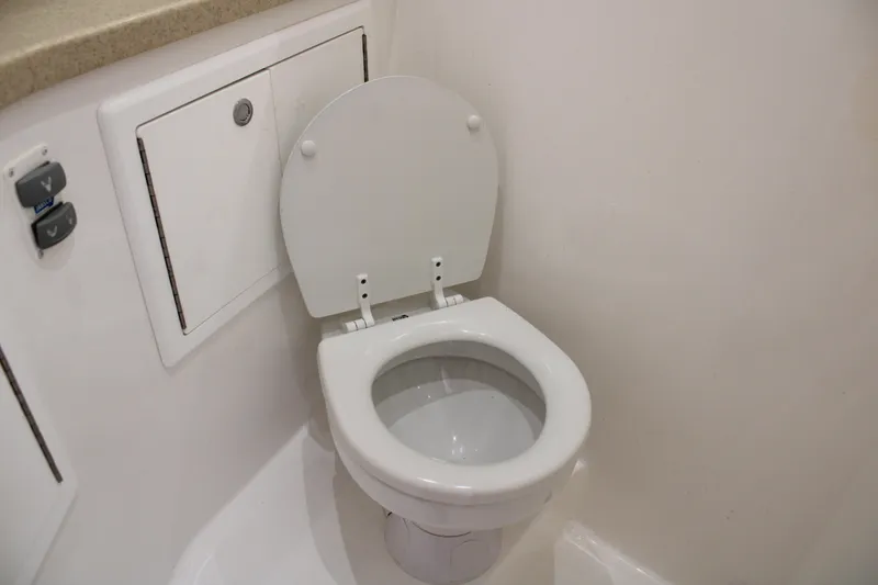 Slide: The Image of 2021 Albemarle 30 Express boat bathroom with white toilet and storage compartment. - 31