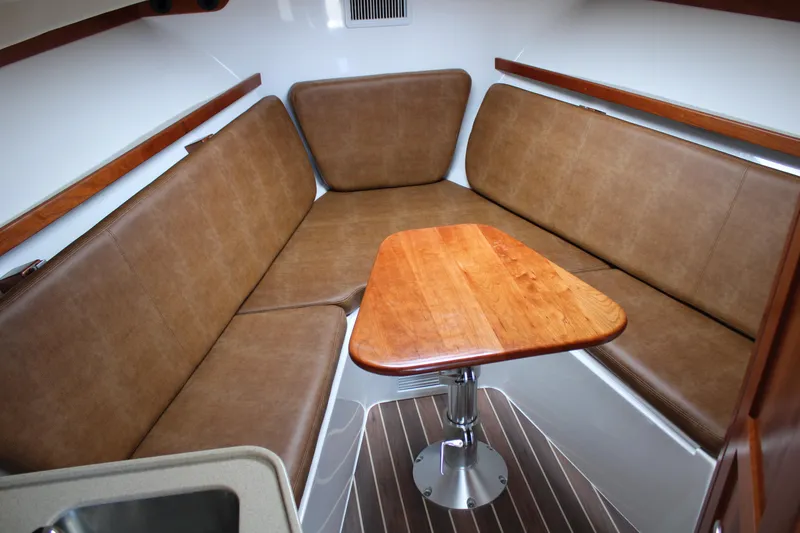 Slide: The Image of Interior of 2021 Albemarle 30 Express boat with brown seating and wooden table. - 34