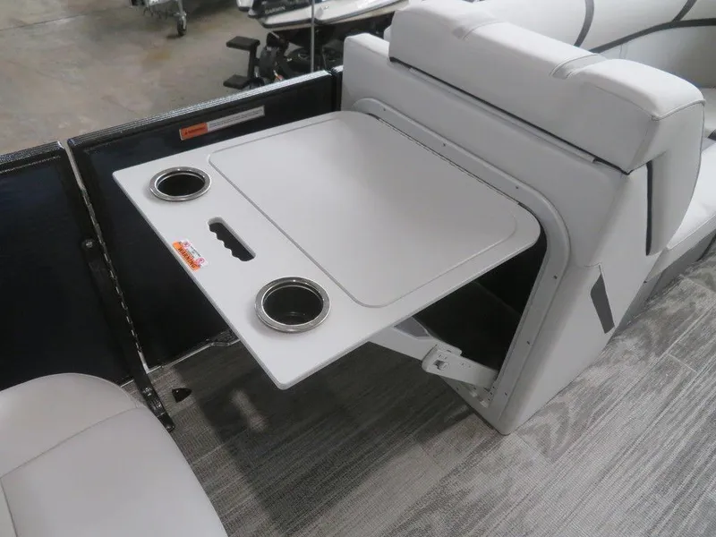 Slide: The Image of 2024 Crest Classic LX 220 SLRC boat interior with foldable table and cup holders. - 10