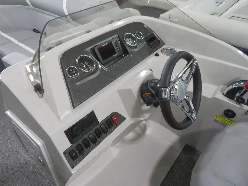 Slide: The Image of 2024 Crest Classic DLX 220 SLSC boat dashboard with steering wheel and control panel. - 5