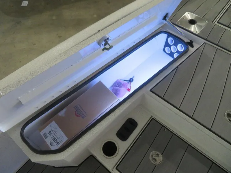 Slide: The Image of 2024 Vexus AVX2180CC boat storage compartment with LED lighting and cup holders. - 23