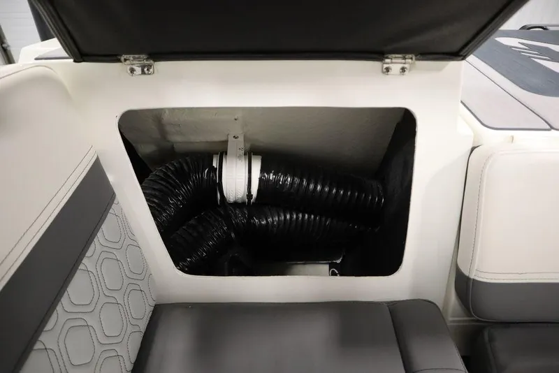 Slide: The Image of Open storage compartment in 2024 Heyday H20 boat, revealing black hoses and interior details. - 48