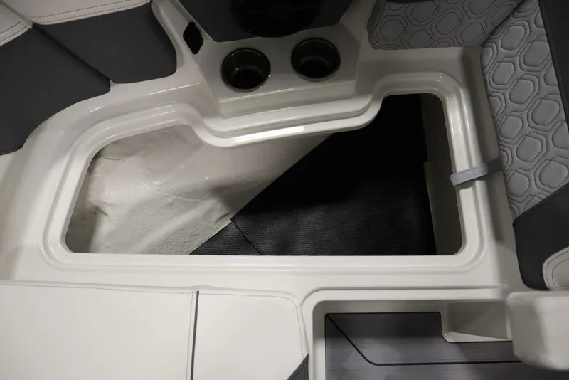 Slide: The Image of 2024 Heyday H20 boat interior storage compartment with cup holders and cushioned seating. - 14