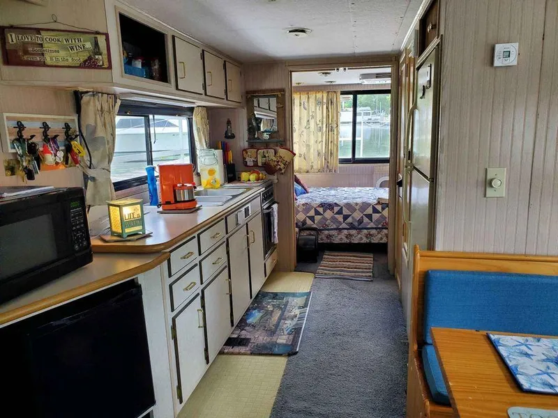 Slide: The Image of Interior of a 1999 Gibson Sport houseboat with kitchen, dining area, and bedroom. - 4