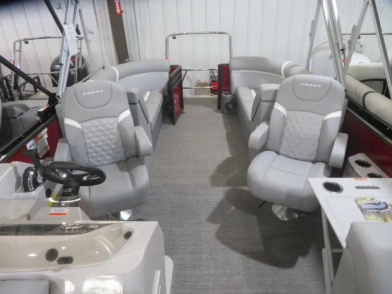 Slide: The Image of 2024 Crest Classic DLX 240 SLC interior with gray seating and modern helm. - 4