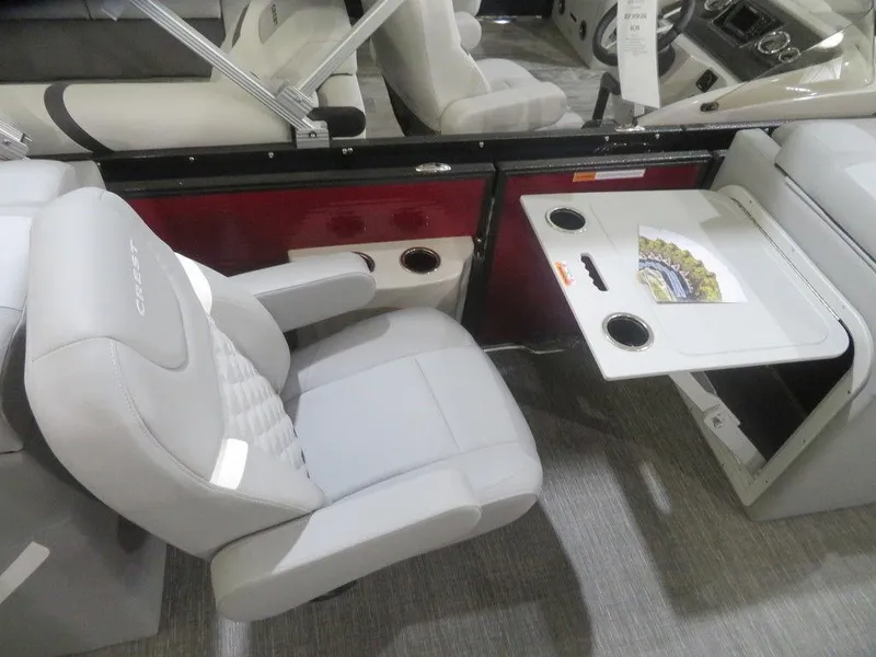 Slide: The Image of 2024 Crest Classic DLX 240 SLC boat interior with seating and fold-out table. - 5