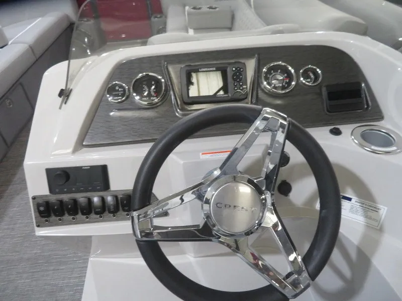 Slide: The Image of 2024 Crest Classic DLX 240 SLC boat dashboard with steering wheel and control panel. - 6