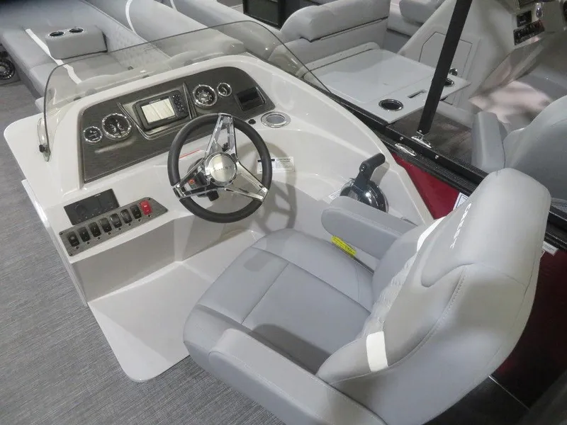 Slide: The Image of 2024 Crest Classic DLX 240 SLC boat helm with modern controls and comfortable captain's chair. - 7