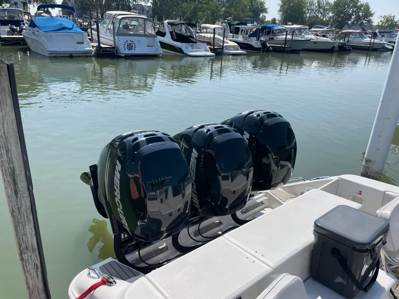 Slide: The Image of 2009 Triton 351CC boat with triple Mercury outboard engines docked at a marina. - 8